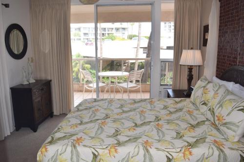 a bedroom with a bed and a balcony at Maui Banyan G310C in Wailea
