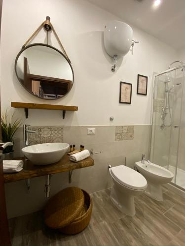 a bathroom with a toilet and a sink and a mirror at La Corte Segreta Tivoli in Tivoli