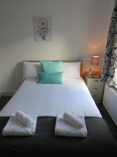 a bed with a white comforter and pillows on it at The Tas Suites - Tas Accommodations in Cambridge
