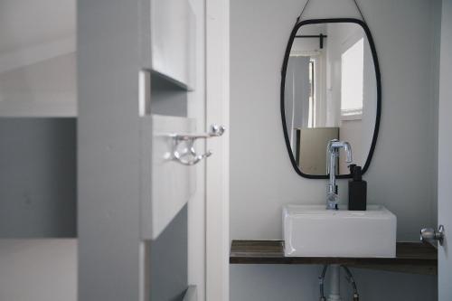 a bathroom with a sink and a mirror at Hugo & Carters Backpackers & Motel in Tauranga