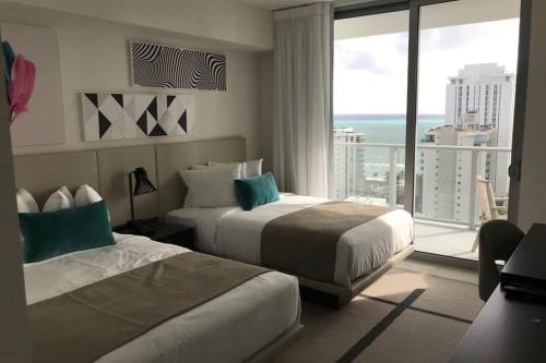 a hotel room with two beds and a large window at Hollywood Beach luxury condo-HBH in Hollywood