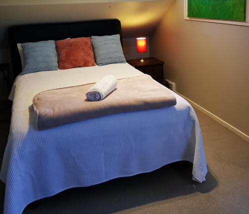 a bedroom with a large bed with a blanket at Regent Residential Villa in Whangarei