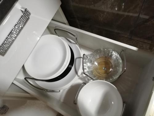 a set of plates and bowls sitting on a shelf at Apartment by the park in Imatra