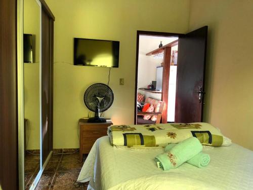 una camera con letto, ventilatore e specchio di casa temporada a Parati