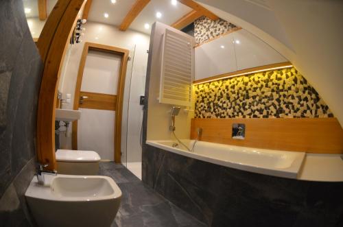 uma casa de banho com um WC, um lavatório e uma banheira em SURF STYLE APARTAMENT em Muszyna