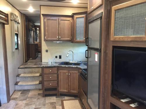 a kitchen in an rv with a sink and a tv at Sequoia Forest Retreat in Badger