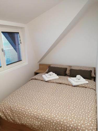 a bedroom with a bed with two towels on it at Apartments NS Novaković in Zlatibor
