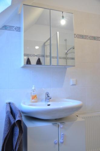 約爾克的住宿－Ferienwohnung Deichapfel im Alten Land (Jork)，浴室设有白色水槽和镜子