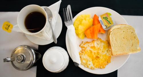 a breakfast plate with eggs and toast and a cup of coffee at Grand Eastern Hotel in Labasa