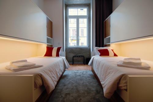 a hotel room with two beds and a window at HI Braga - Pousada de Juventude in Braga