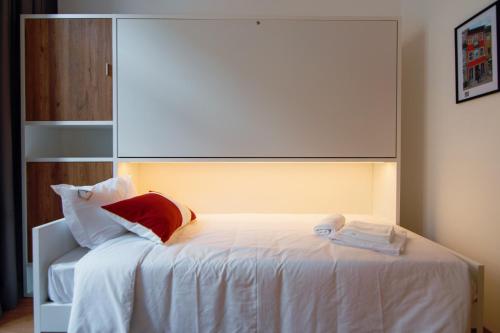 a bedroom with a white bed with a red pillow at HI Braga - Pousada de Juventude in Braga