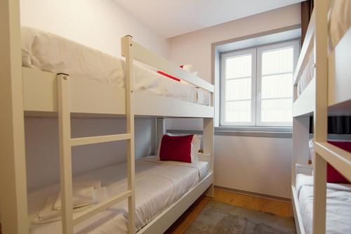 a small room with bunk beds and a window at HI Braga - Pousada de Juventude in Braga