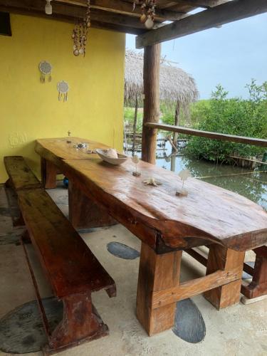 einen Holztisch mit einer Bank in einem Zimmer in der Unterkunft Kiosko uva playa frente al mar in San Onofre