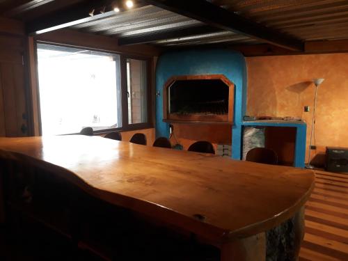uma grande mesa de madeira num quarto com uma grande janela em Samadhi Lodge Pingueral em Dichato