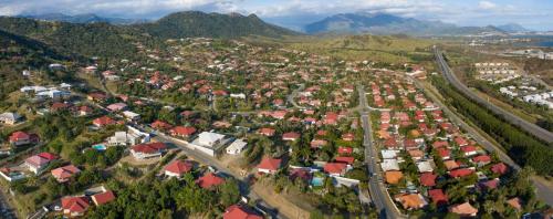 an aerial view of a city with houses and mountains at Le Médipole in Noumea