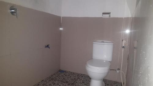 a bathroom with a white toilet in a room at Tetebatu Indah Homestay in Tetebatu