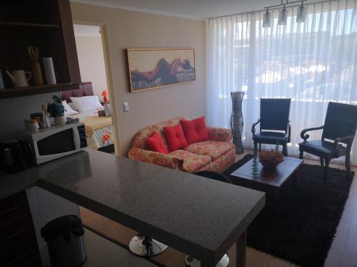 uma sala de estar com um sofá e almofadas vermelhas em Depto 1 Dormitorio Centro Blanco 702 em Temuco