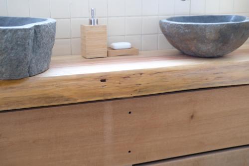 a bathroom with a large stone sink on a wooden counter at HA-MON Slope Side Hotel and Private Chalet in Otari