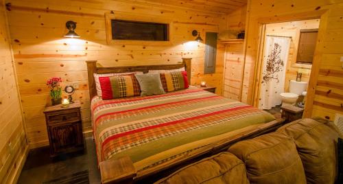 a bedroom with a bed in a log cabin at Sunsettin Cabin Free Parking Onsite in Stephens Gap