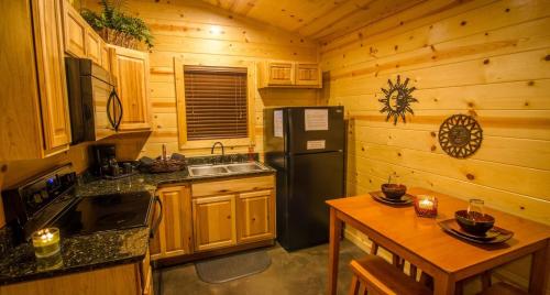 a kitchen with a black refrigerator and a table at Sunsettin Cabin Free Parking Onsite in Stephens Gap