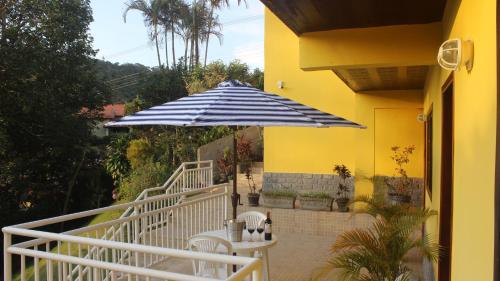 a blue and white umbrella sitting next to a building at Luxor Flat`s in Miguel Pereira