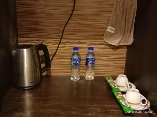 two bottles of water sitting on top of a table at Izz room studio Gold Coast Morib Resort in Banting