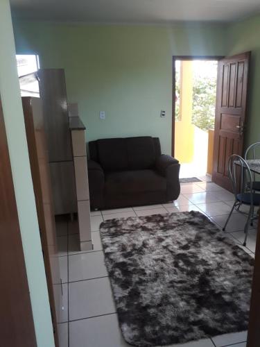 a living room with a couch and a table at Hospedagem da Rose in Marataizes