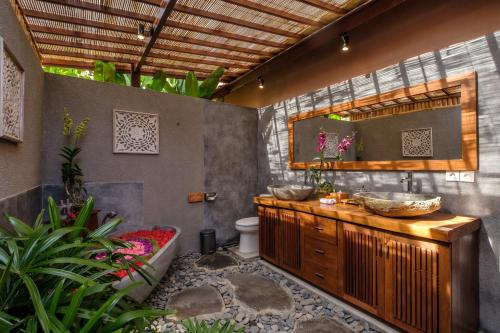een badkamer met 2 wastafels en een bad bij A home, like a dream in Ubud