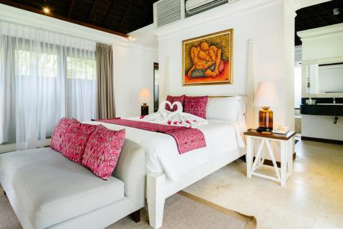 a white bedroom with a bed and a couch at Avillion Villa Cinta @Sanur, Bali in Sanur