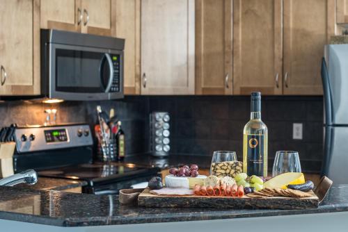 a kitchen counter with a cutting board with a bottle of wine at Modern Cozy 2 Bed 2 Bath with Lake and Mountain Views Pool and Hot Tub in Invermere