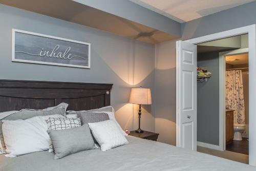 a bedroom with a bed with white and gray pillows at Modern Cozy 2 Bed 2 Bath with Lake and Mountain Views Pool and Hot Tub in Invermere