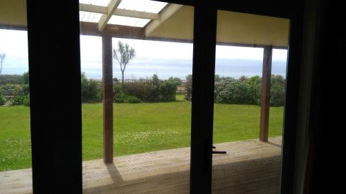 a window view of a field from a house at Awatuna Sunset Lodge in Hokitika