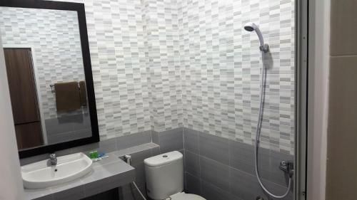 a bathroom with a toilet and a sink and a shower at Nasional Hotel in Gunungsitoli