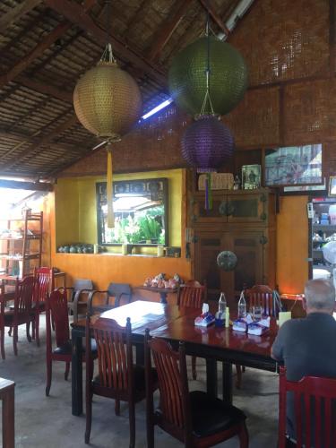 a dining room with tables and chairs and chandeliers at Andaman Sunflower in Ko Lanta