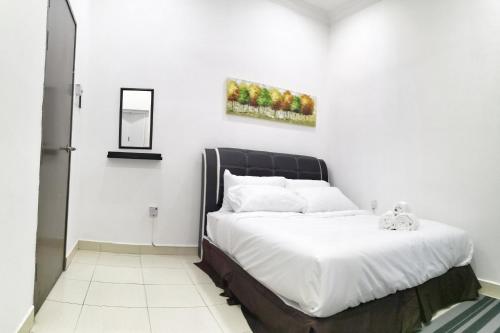 1 dormitorio con 1 cama con cabecero negro en Teratak Persona Homestay. 4 rooms double storey terrace in Kuantan City., en Kuantan