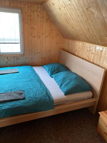 MalenoviceにあるMalenka u sjezdovky pro 10 osobの木製の部屋のベッド1台(青い枕付)