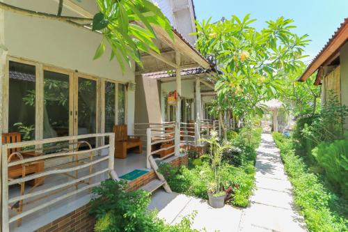 une terrasse couverte d'une maison avec des arbres et des plantes dans l'établissement Angels Bungalow Nusa Penida, à Nusa Penida
