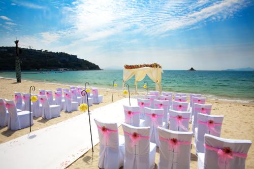 a row of white chairs on a beach at Intercontinental Shenzhen Dameisha Resort by IHG in Shenzhen