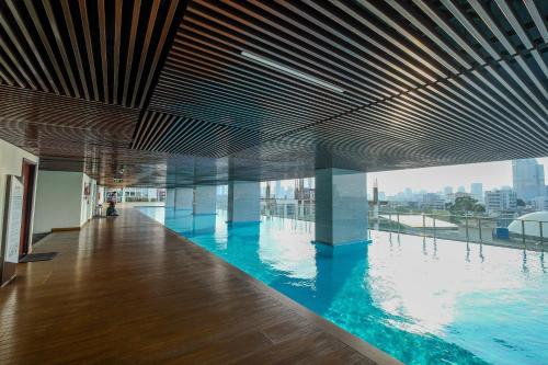 a large swimming pool in a building with a view at Minimalist and Homey Studio Menteng Park Apartment By Travelio in Jakarta