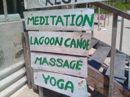 a group of signs that say meditationocation lagoonamamineassociate yogacca at The Alpha Monkey hotel & Tree house in Tangalle