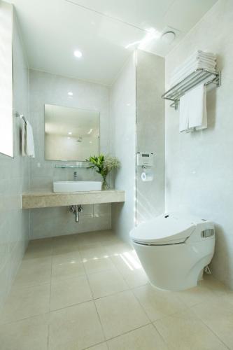 a white bathroom with a toilet and a sink at Hotel Nafore in Seoul