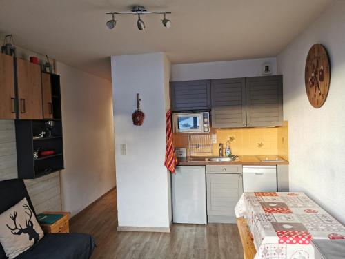 a small kitchen with a white refrigerator and a sink at Studio le Grand-Bornand Village in Le Grand-Bornand