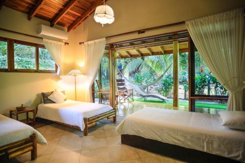 a bedroom with two beds and a balcony at Villas Santa Teresa in Santa Teresa Beach