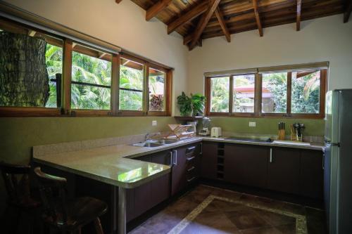 a kitchen with a sink and a refrigerator at Villas Santa Teresa in Santa Teresa Beach