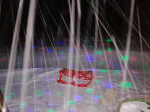 a red object is seen through a window with lights at Vikendica RANKOVIĆI in Mokra Gora