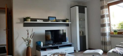 een woonkamer met een flatscreen-tv op een entertainmentcentrum bij Gästehaus Probst in Alken