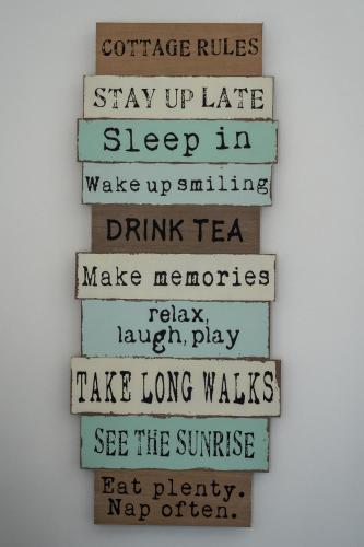 a stack of reclaimed wood signs hanging on a wall at The Annex at Church View Barn in Snitterby