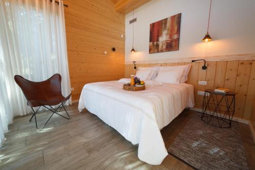 a bedroom with a white bed and a chair at Rinoterra Minho in Caminha