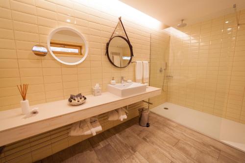 a bathroom with a sink and a mirror and a tub at Rinoterra Minho in Caminha