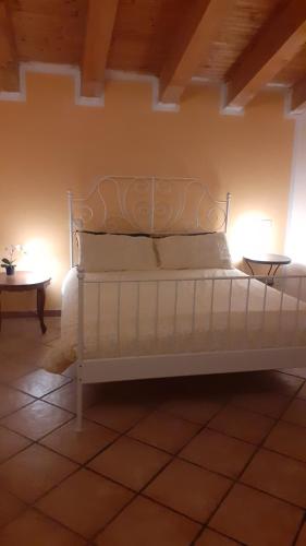 un letto bianco in una stanza con tavolo di Casa Coiri a Cairo Montenotte